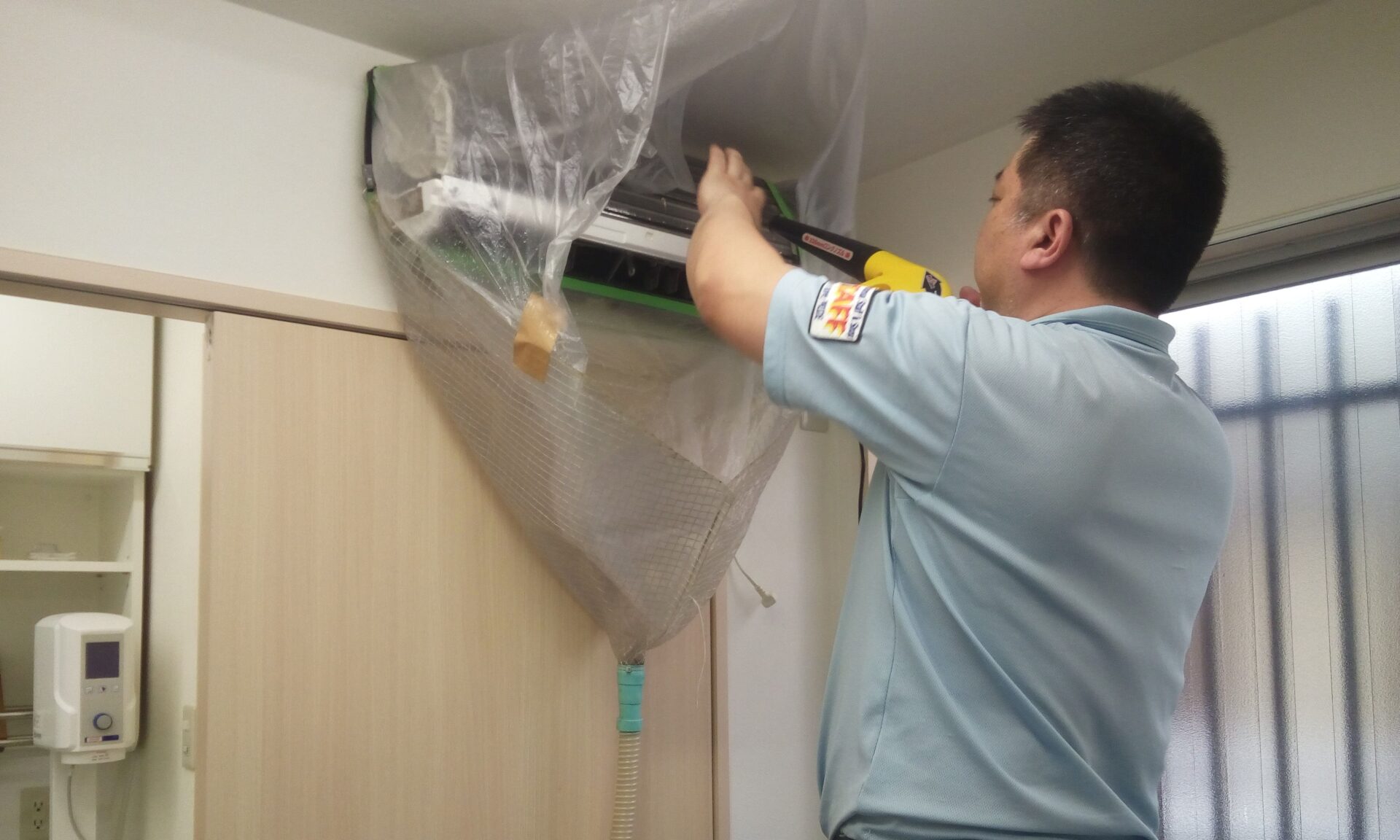 エアコンクリーニングをしている男性スタッフ